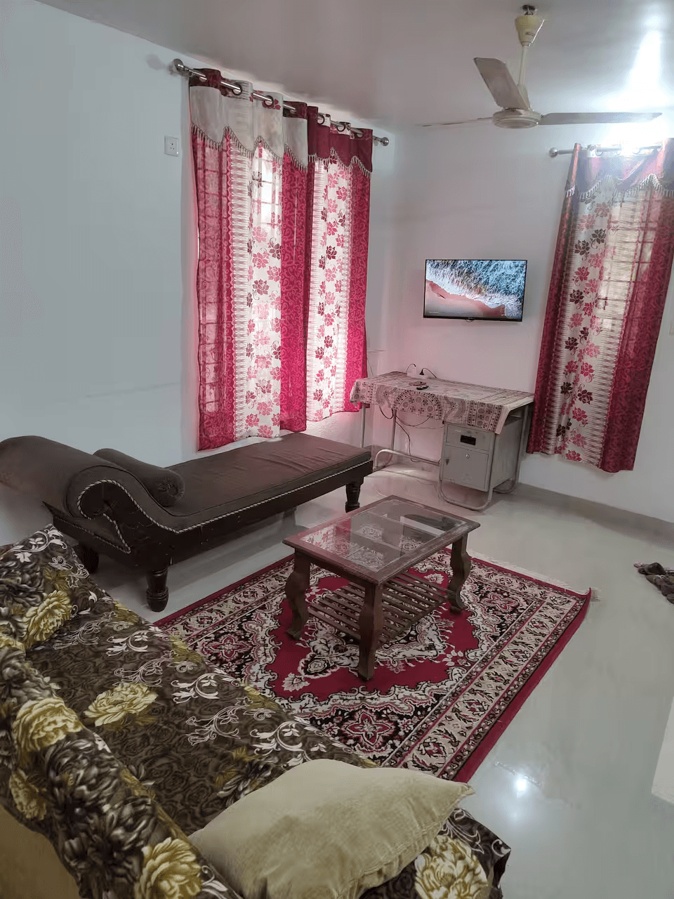 Living room with sofa, diwan, and TV in Kesu's Villa